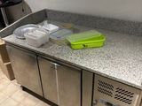 a kitchen counter with a sink and a refrigerator in it