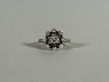a close up of a white and black diamond ring on a white surface
