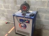 a machine that is sitting on the ground next to a brick wall