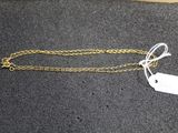a close up of a gold chain with a tag on it