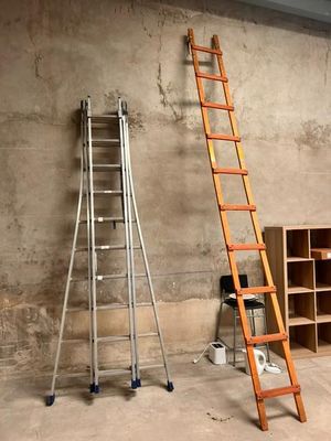 two ladders that are leaning against a wall