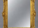 un miroir orné d'un cadre doré au motif décoratif