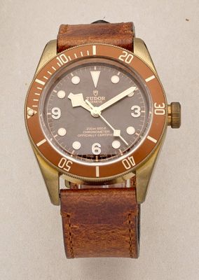 a brown and gold watch with a brown leather strap