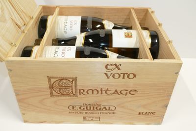 des bouteilles de vin se trouvent dans un coffret en bois sur une table