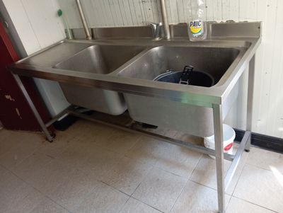 two sinks in the kitchen with a bottle of water on the counter