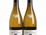 two bottles of white wine sitting next to each other on a white surface