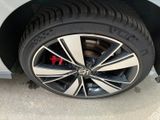 the tire of a white car with black spokes and a red star on the rim