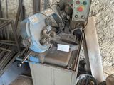une machine posée par terre à côté d'un tas de bois