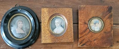 two framed portraits of a woman and a man on a wooden wall
