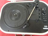 une platine avec un tourne-disque posé dessus, sur une surface rouge