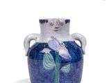 a blue vase with a bird on it sitting on a table
