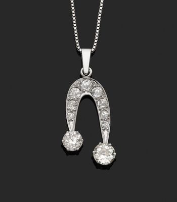 un pendentif en forme de fer à cheval serti d'un diamant,