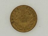 a close up of a gold coin on a white surface