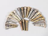 a lot of different types of brass pipes on a white surface
