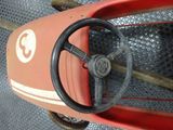 a red toy car with a steering and a steering wheel