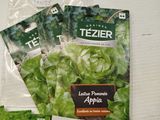 a bag of lettuce and a packet of seedlings on a table