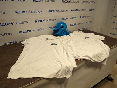 une pile de t-shirts blancs posés sur une table devant un mur