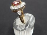 a close up of a pink and white diamond ring on a clear base