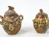 two vases with lids decorated with birds and flowers on them
