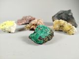 several different colored rocks are arranged on a white surface