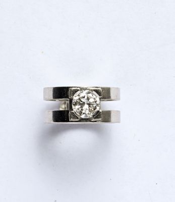 une photo d'une bague en diamant posée sur une surface blanche