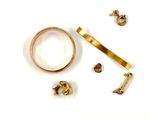 a gold ring and a pair of earrings on a white surface