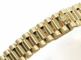 a close up of a gold watch bracelet with a diamond on it