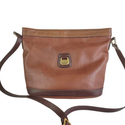the brown leather bag has a metal clasp on it