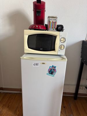 un réfrigérateur blanc surmonté d'un micro-ondes