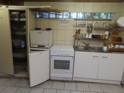 a small kitchen with a refrigerator, stove, and sink