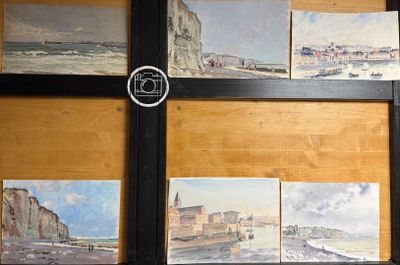 de nombreux tableaux accrochés au mur d'une pièce où se trouve une horloge
