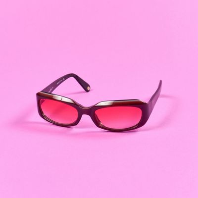 un gros plan sur une paire de lunettes de soleil sur fond rose