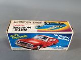 an old model of a red car in a box on a table