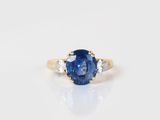 a blue sapphire and diamond ring on a white surface