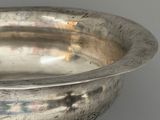 an antique silver bowl on a stand on a gray background