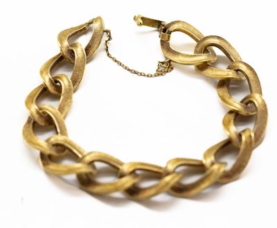 gros plan d'un bracelet en chaîne en or sur fond blanc