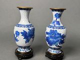 pair of blue and white vases sitting on top of a wooden stand