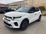 the white suv is parked in a parking lot near a building