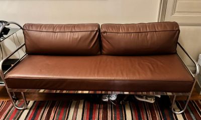 un canapé en cuir marron posé sur un tapis dans un salon