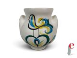 un vase blanc orné d'un motif bleu et jaune