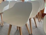 four white chairs sitting in front of a window in a room