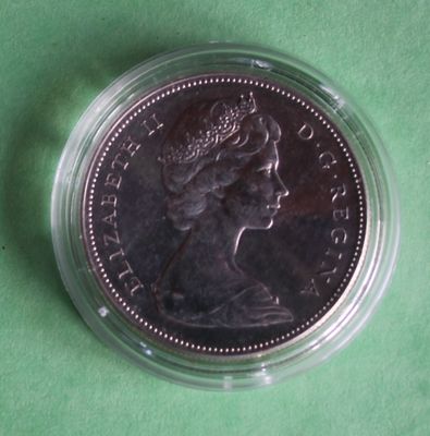 the coin is in a clear plastic container on a green surface