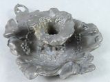 a silver candle holder with a flower on top of it