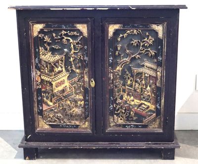 une armoire noire ornée d'un motif noir et doré