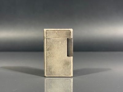 un vieux briquet posé sur une table près d'un mur gris