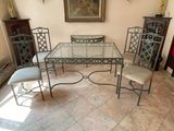 a glass table and chairs in a room with a painting on the wall