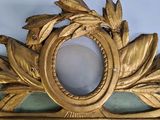 a gold frame with a leaf decoration on top of it