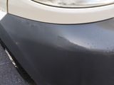 a close up of a car ' s front bumper with a denting on it