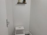 a small white chair in the corner of a small room