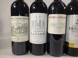 several bottles of red wine are lined up on a counter